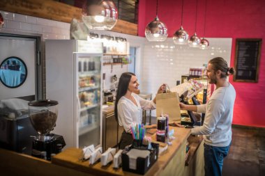 Güzel, keyifli bir kasiyer sürekli müşterisine sipariş veriyor.