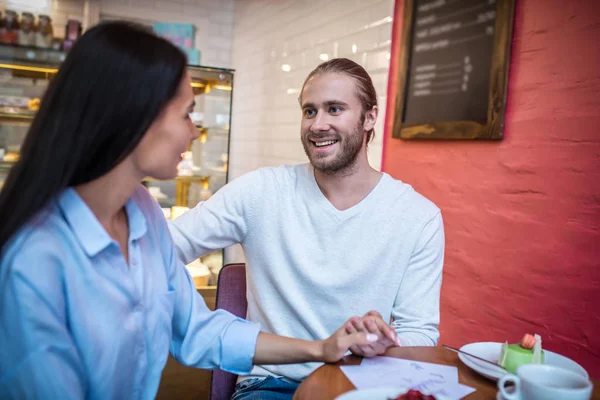 Loving bearded husband hugging wife while sitting in cafeteria — Stock Photo, Image