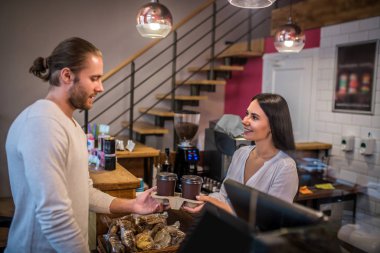 Sakallı adam en sevdiği kahveciden kahve alıyor.