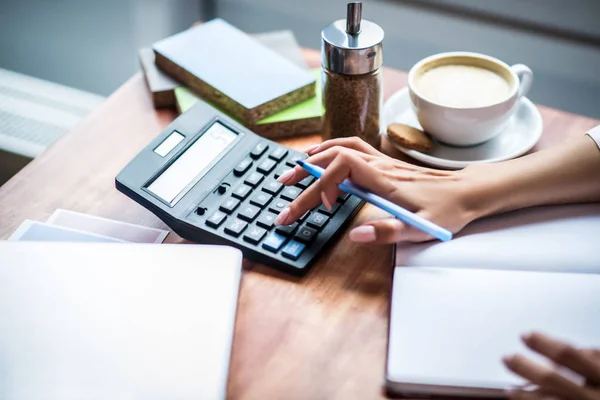 Primer plano de la mujer usando la calculadora mientras calcula los gastos —  Fotos de Stock