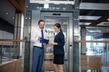 Business lady smiling while listening to her business partner