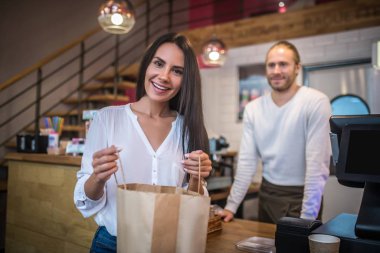 Ay çöreği aldıktan sonra eve götürmek için çanta tutan kadın.