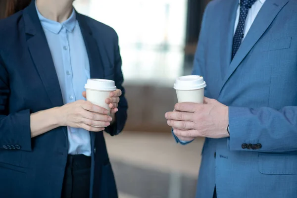 Gros plan de l'homme d'affaires et de la femme d'affaires tenant un café à emporter — Photo