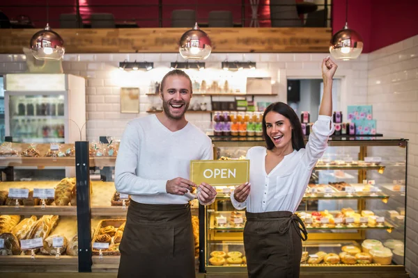 Cheerful couple feeling truly happy while opening their own bakery — Stock Photo, Image