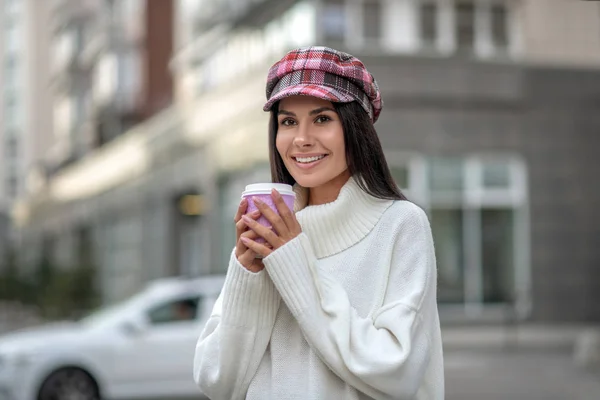 Mujer alegre positiva sosteniendo una taza con café —  Fotos de Stock