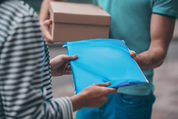 Woman taking her parcel while meeting delivery man — Stok fotoğraf