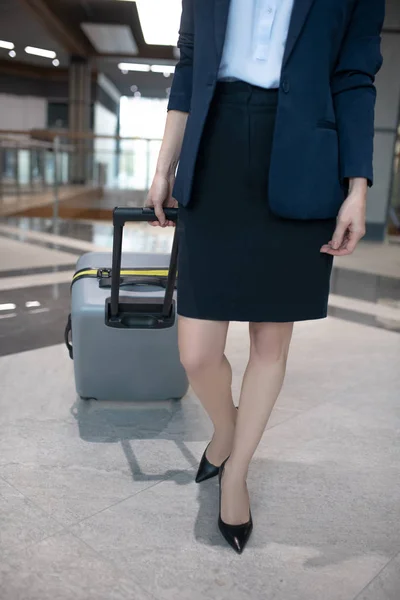 Businesswoman nosit tmavé kožené boty chůze s jejím zavazadlem — Stock fotografie