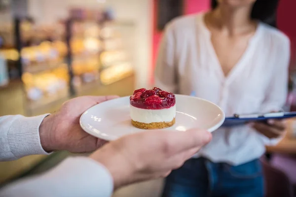Man holding plate with nice yummy raspberry cheesecake — Stock Photo, Image