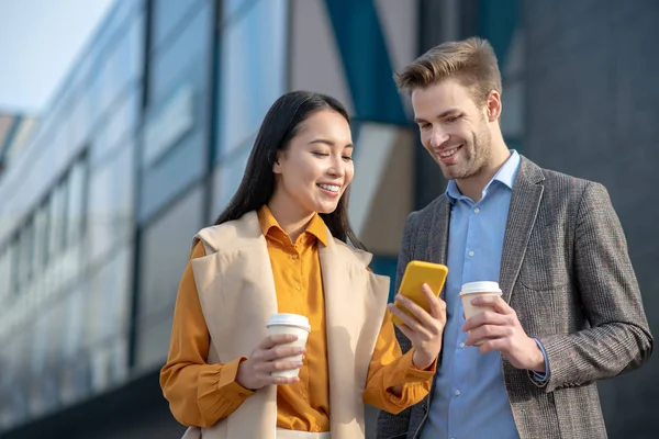 Homem e mulher olhando para as fotos em um smartphone — Fotografia de Stock