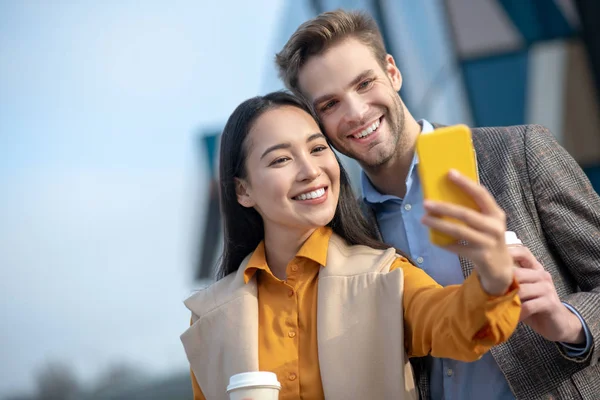 Homem e mulher sorrindo alegremente para a câmera — Fotografia de Stock