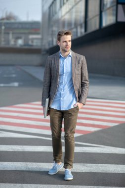 Karşıdan karşıya geçerken mavi gömlekli yakışıklı bir genç.