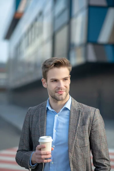 Ung stilig man i jacka med en kopp kaffe — Stockfoto