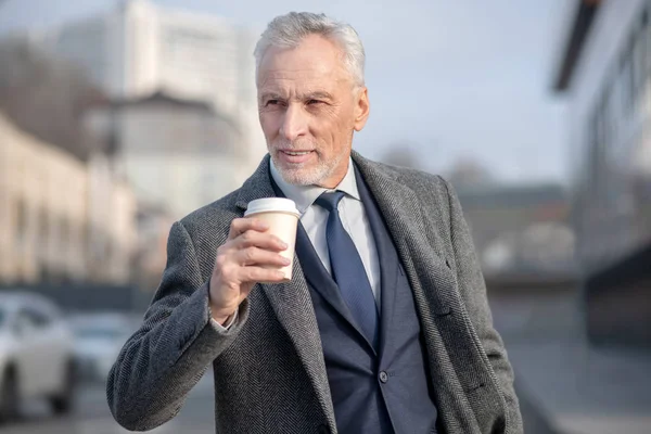 Reifer Mann im eleganten Mantel beim Kaffee — Stockfoto