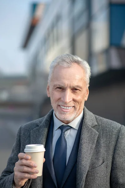 Volwassen man in elegante jas glimlachend — Stockfoto