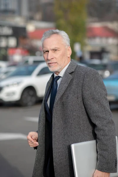 Hombre de pelo gris usando un abrigo gris que parece cansado — Foto de Stock