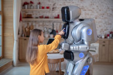 Robotların programlama panelindeki düğmelere basan tatlı kız.