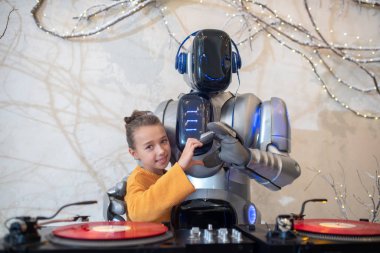 Robot DJ ve kalp işaretini gösteren bir kız.