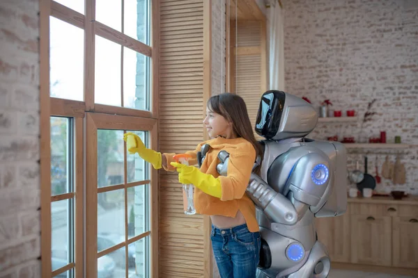 Dziewczyna w żółtych rękawiczkach ochronnych czyszczenie okna — Zdjęcie stockowe