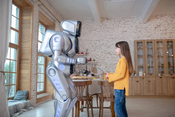 Robot and a cute girl talking in the kitchen — Stock Photo, Image
