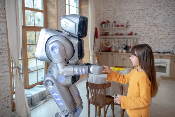 Robot y una linda chica de pie en la cocina —  Fotos de Stock