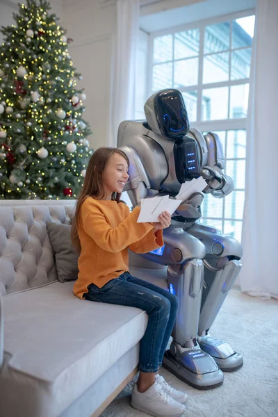 Robot and a cute girl sitting on the sofa — Stock Photo, Image