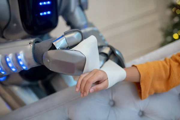Robot carefully attaching bandage on girls wrist — Stock Photo, Image