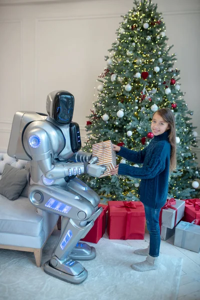 Robot and a cute girl exchanging christmas gifts