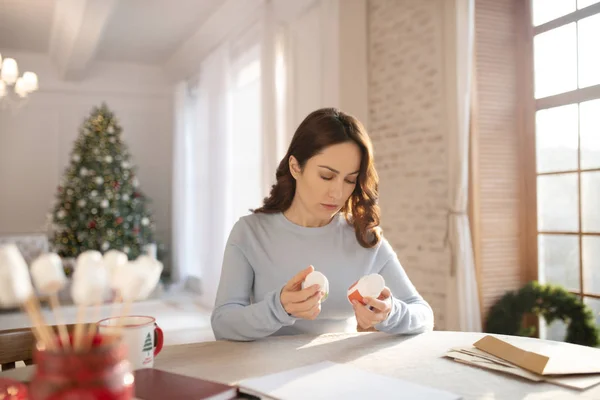 Vrouw met lang haar pillen in haar handen — Stockfoto