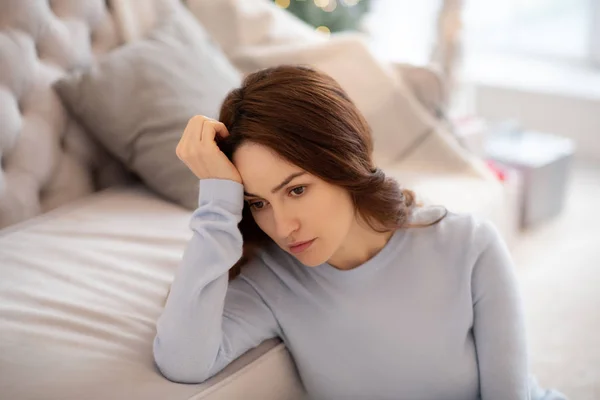 Mujer bonita en ropa de casa gris buscando deprimida — Foto de Stock