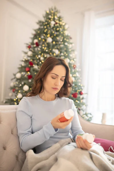 Mörkhårig ung vacker kvinna väljer vitaminer för henne — Stockfoto