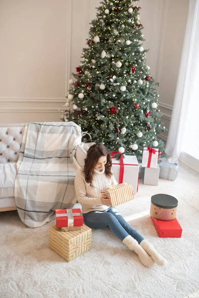 Jeune femme aux cheveux bruns profitant de ses cadeaux de Noël — Photo