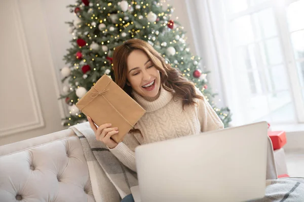 Mooie donkerharige vrouw in lichte trui die mooi glimlacht — Stockfoto