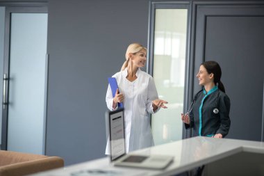 Stajyer ve kıdemli doktor doktorların ofisinde konuşuyor.