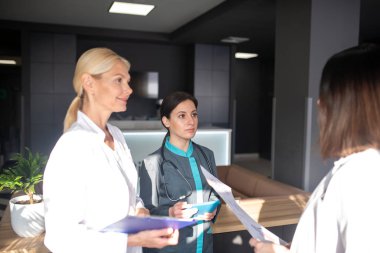 Üç kadın doktor iş yerinde iyi görünüyor.