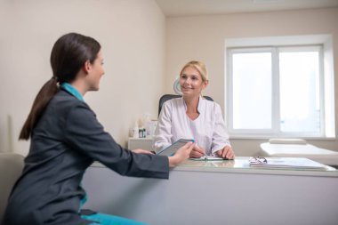 Ofisteki masada oturan iki kadın doktor.