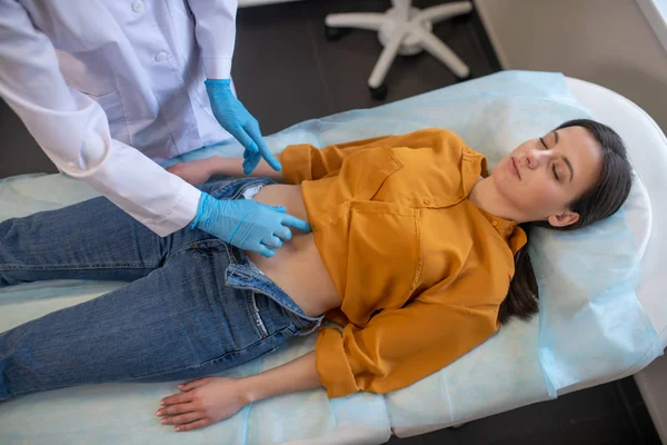 Paziente femminile sdraiata su un divano nello studio medico — Foto Stock