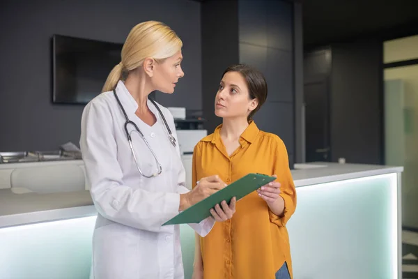 Médico rubio ayudando en bata blanca buscando ocupado — Foto de Stock