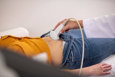 Kadın doktor hamile kadına ultrason testi yapıyor.