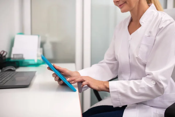 Biondo medico piacevole toccare lo schermo del tablet — Foto Stock