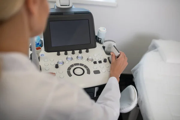 Nahaufnahme eines blonden Arztes mittels Ultraschallgerät-Tastatur — Stockfoto