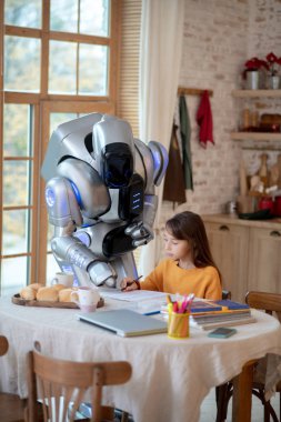 Robot öğretmen yazarken hataya işaret ediyor