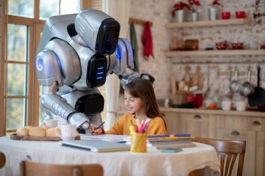 Robot elini gülümseyen bir kızın kafasına koyuyor.
