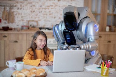 Robot ve turuncu gömlekli bir kız eğlendiler.