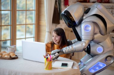 Robot ve turuncu tişörtlü kız meşgul görünüyorlar.