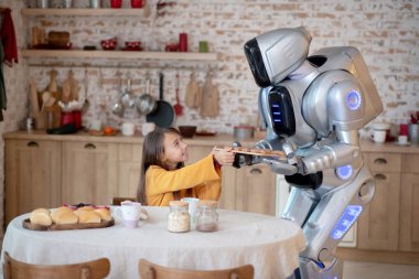 Ev robotu masadaki kıza köfte ikram ediyor.