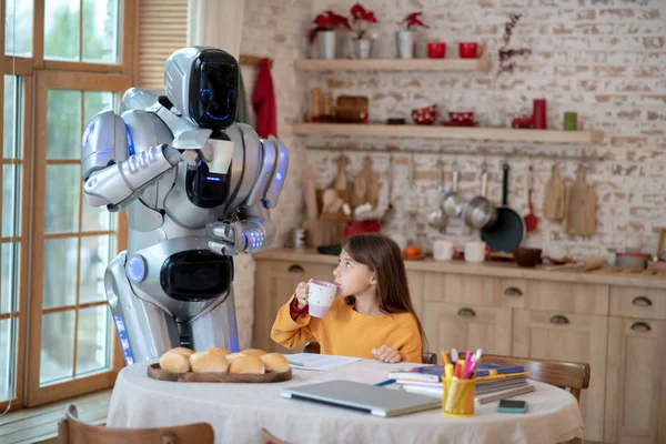 Şirin kız ve ev robotu çay içiyorlar. — Stok fotoğraf