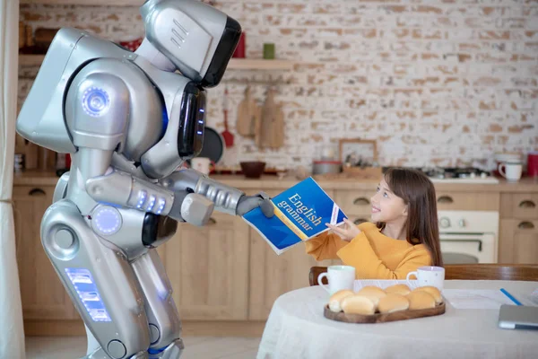 Robot giving english grammar book to a girl