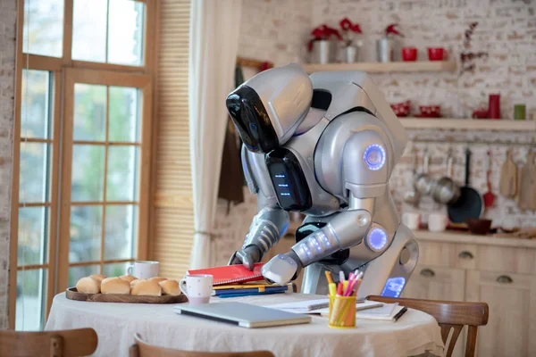 Robot conseguir libros y cuadernos de la mesa —  Fotos de Stock