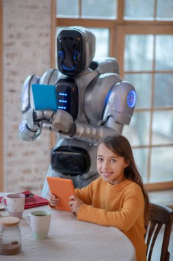 Elinde tabletle resim yapan bir robot.
