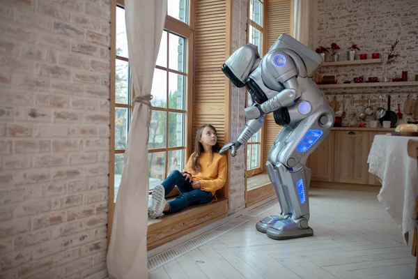 Robot talking to the girl sitting at the window — Stock Photo, Image